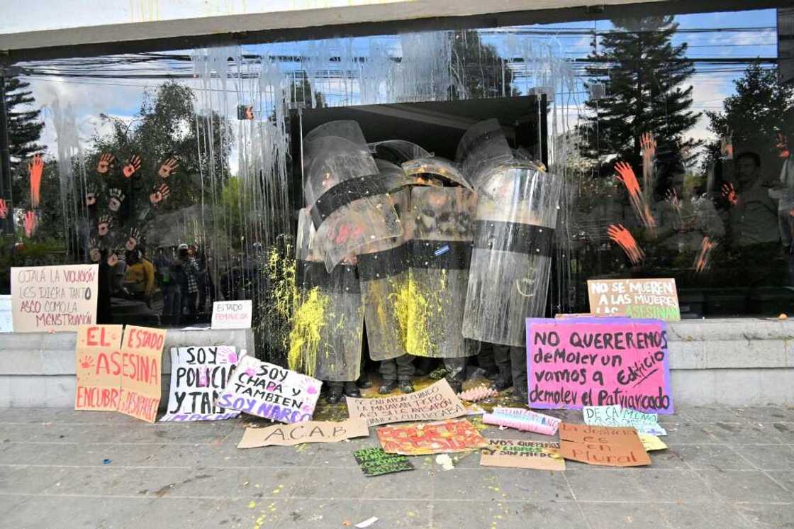 Officers in riot gear stand guard as a group of women protest in front of Ecuador's police headquarters Officers in riot gear stand guard as a group of women protest in front of Ecuador's police headquarters