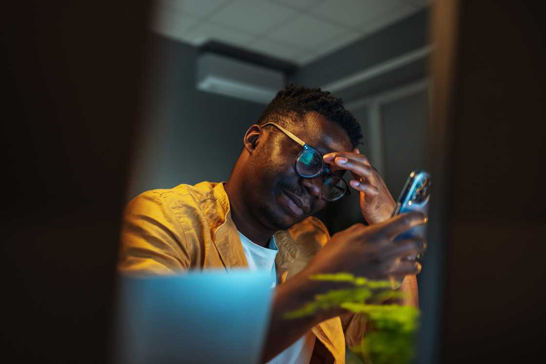 A shocked man looking at his phone at night A shocked man looking at his phone at night