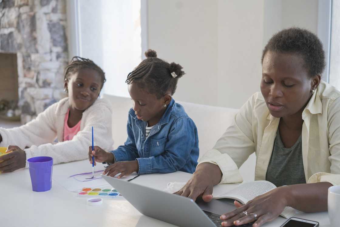 A mother and her two kid playing games.