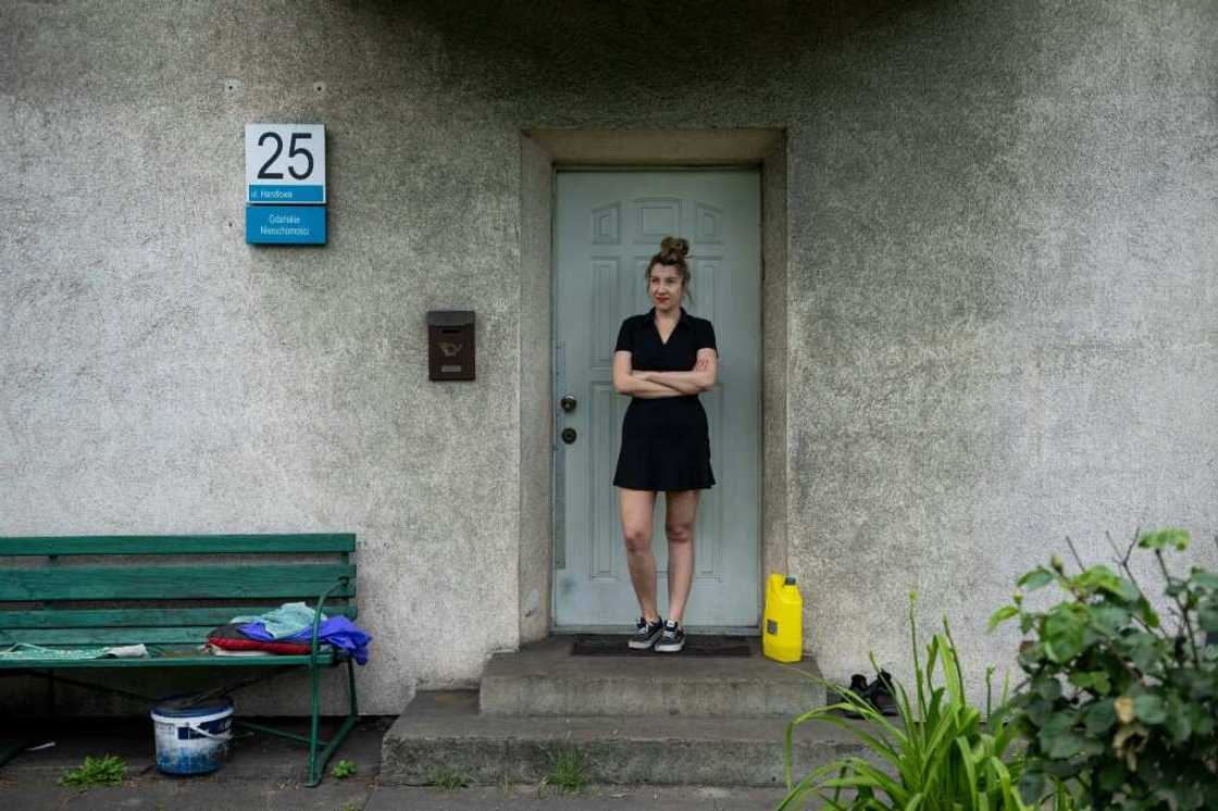 Iwona Wozniewska stands in front of the door of her home in Gdansk, Poland, blackened by coal dust