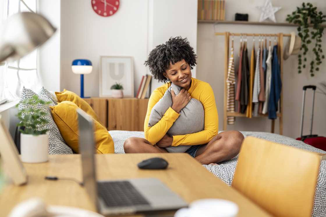 Young woman sitting on a bed Young woman sitting on a bed
