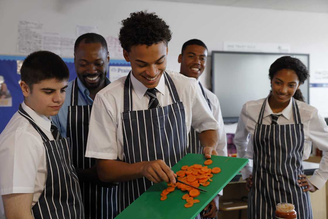 A teacher supervises students during a practical session