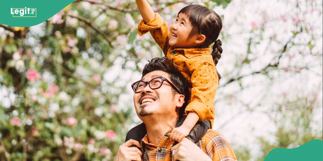 Chinese man plays with daughter in a public park. Chinese man plays with daughter in a public park.