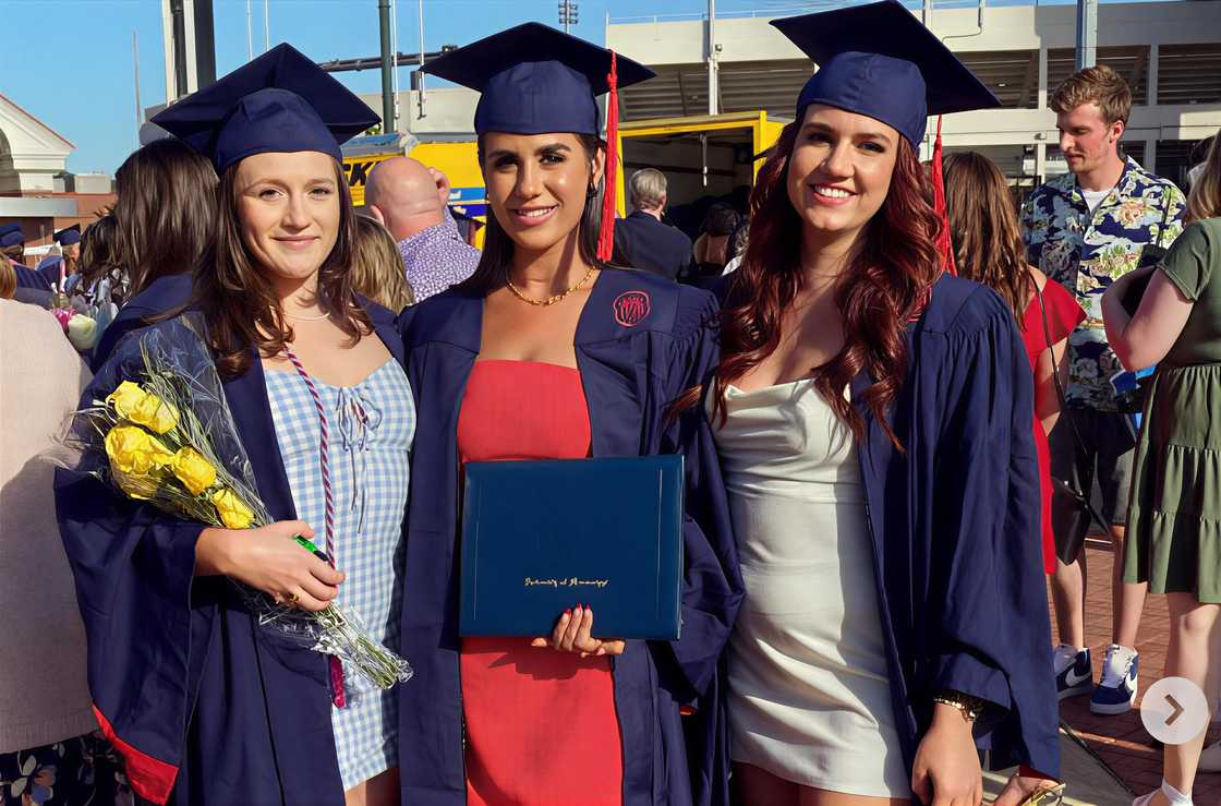 Madison Scarpino (C) with two female students taking a photo after graduating Madison Scarpino (C) with two female students taking a photo after graduating