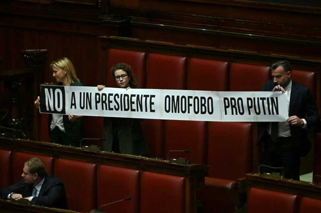 Members of the centre-left Democratic Party held up a banner in parliament reading: 'No to a homophobic and pro-Putin speaker' Members of the centre-left Democratic Party held up a banner in parliament reading: 'No to a homophobic and pro-Putin speaker'