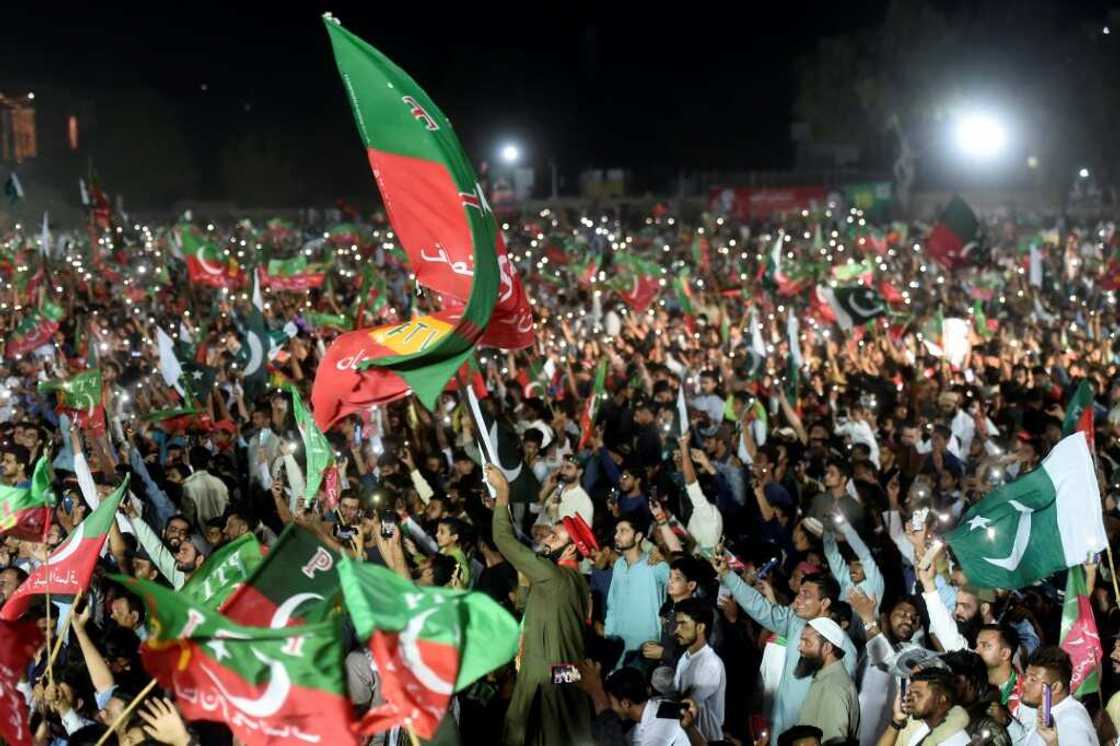 Supporters of former Pakistan prime minister Imran Khan wave flags during his speech in Karachi Supporters of former Pakistan prime minister Imran Khan wave flags during his speech in Karachi