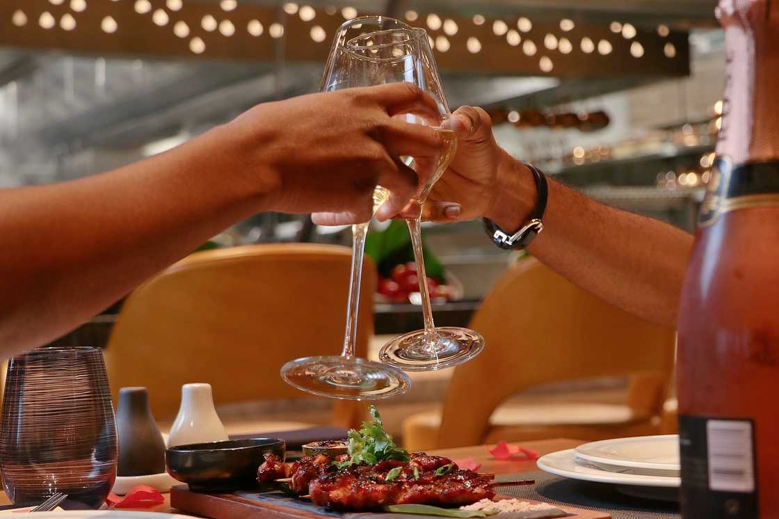 Two guests click their wine glasses together at Wakame Restaurant, Lagos Two guests click their wine glasses together at Wakame Restaurant, Lagos