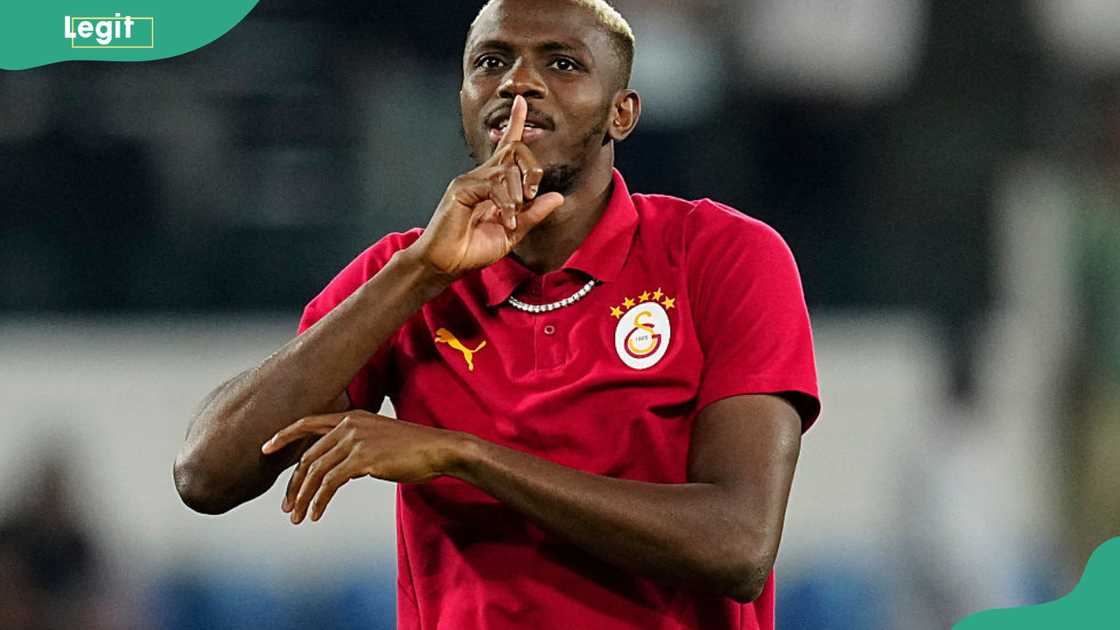 Victor Osimhen in a red Galatasaray shirt with bleached blond hair, holding a finger to his lips Victor Osimhen in a red Galatasaray shirt with bleached blond hair, holding a finger to his lips
