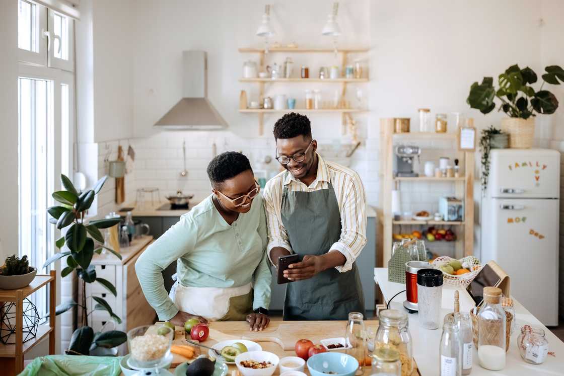 A man edits video on the phone while woman watches. A man edits video on the phone while woman watches.