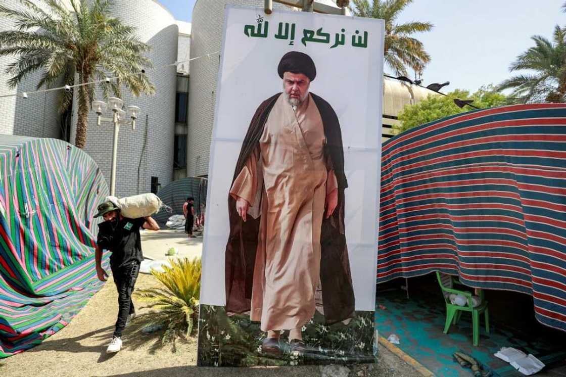 A Sadr supporter carries away items as they leave Baghdad's Green Zone A Sadr supporter carries away items as they leave Baghdad's Green Zone