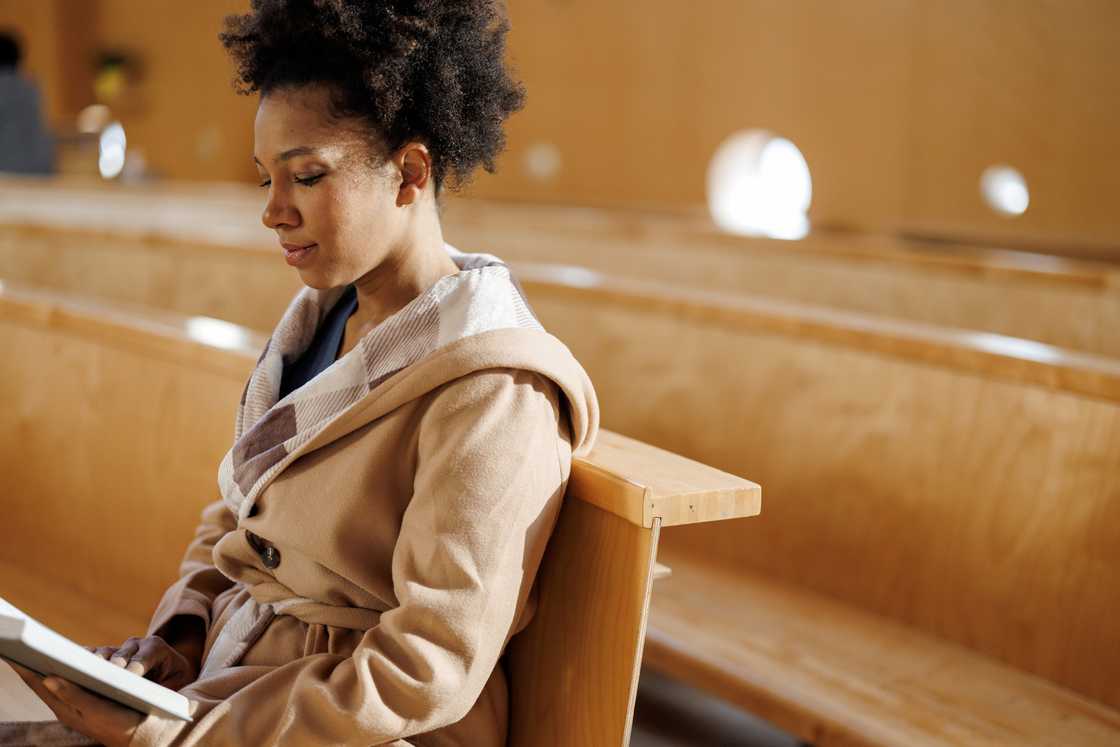A young woman holding Bible during sermon
