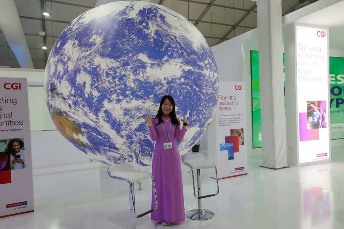 A delegate poses for a picture in an exhibitions pavilion at the convention center hosting the COP27 climate conference A delegate poses for a picture in an exhibitions pavilion at the convention center hosting the COP27 climate conference