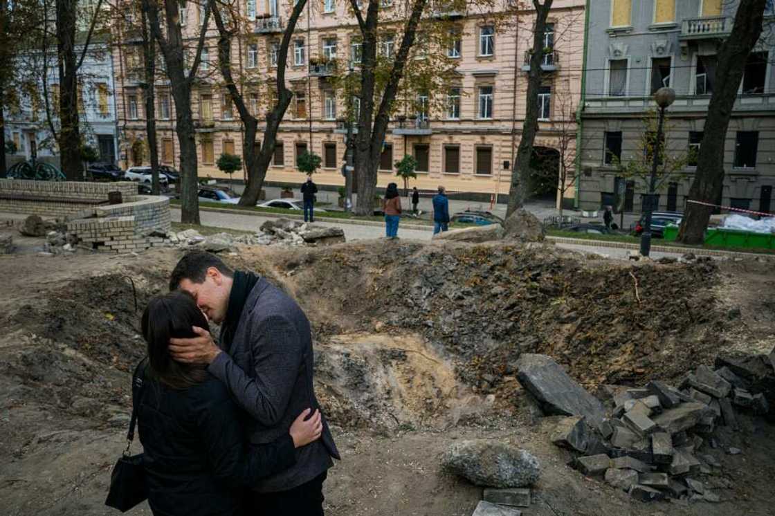 The IMF chief praised the 'incredible resilience of the Ukrainian people. Here a couple kiss by a rocket crater in a park of central Kyiv earlier this month The IMF chief praised the 'incredible resilience of the Ukrainian people. Here a couple kiss by a rocket crater in a park of central Kyiv earlier this month