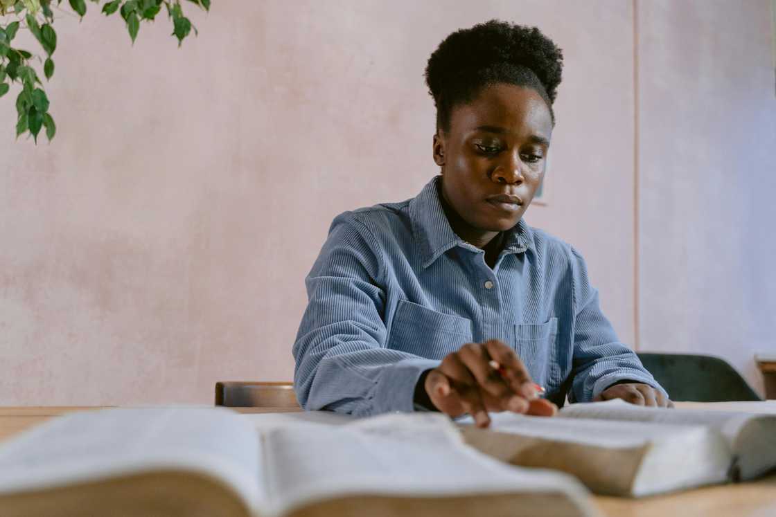A young woman in a blue shirt is studying A young woman in a blue shirt is studying