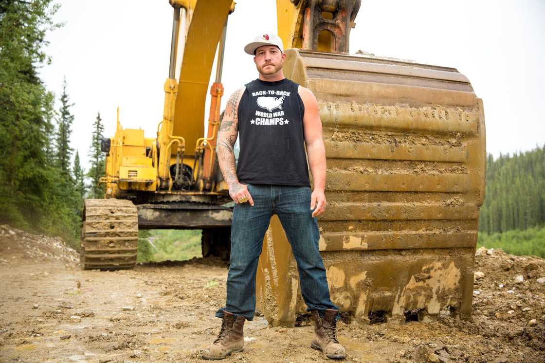 Rick Ness posing in front of an excavator Rick Ness posing in front of an excavator