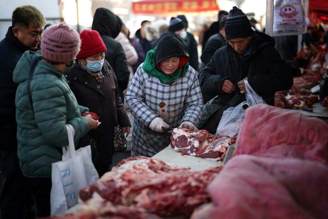 A vendor cuts meat for customers at a market in Shenyang, in China's northeastern Liaoning province in January A vendor cuts meat for customers at a market in Shenyang, in China's northeastern Liaoning province in January