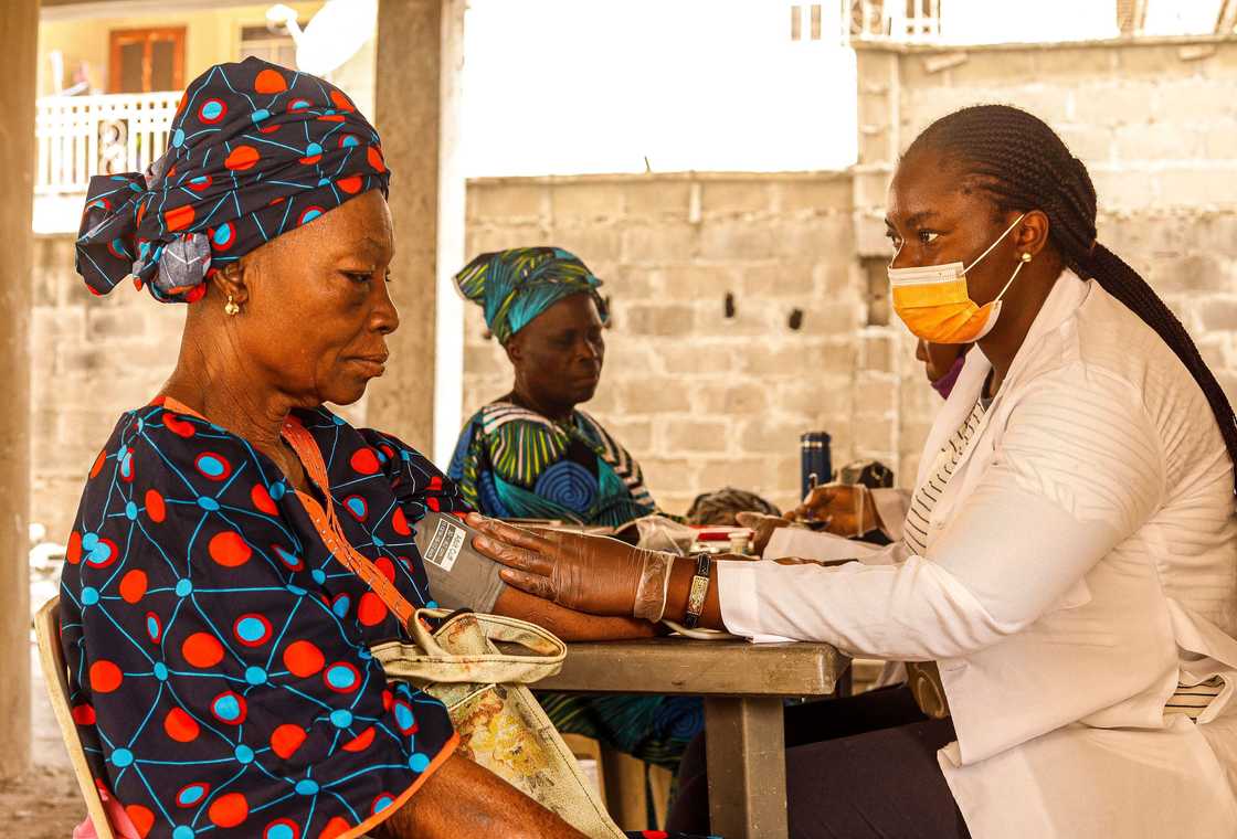 A medical professional checks blood pressure of a woman A medical professional checks blood pressure of a woman