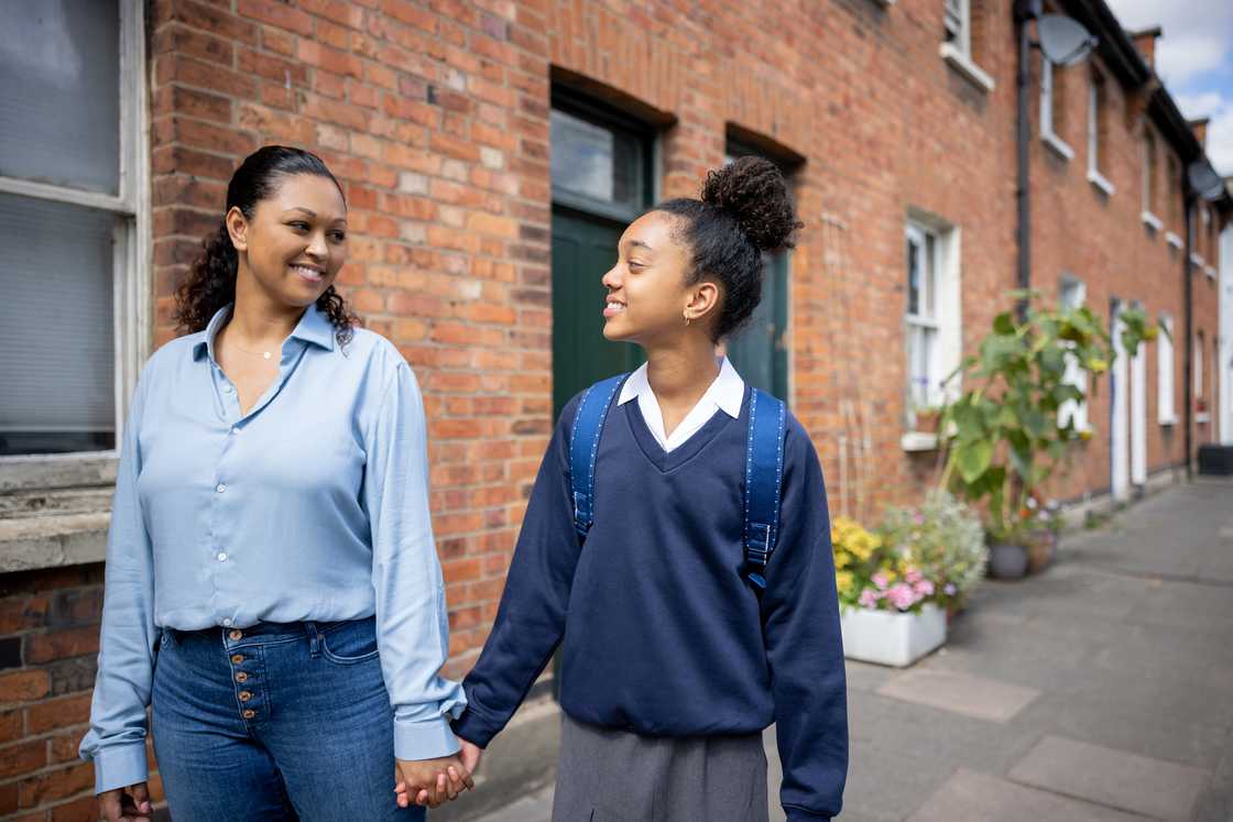 A loving mother taking her daughter to school A loving mother taking her daughter to school