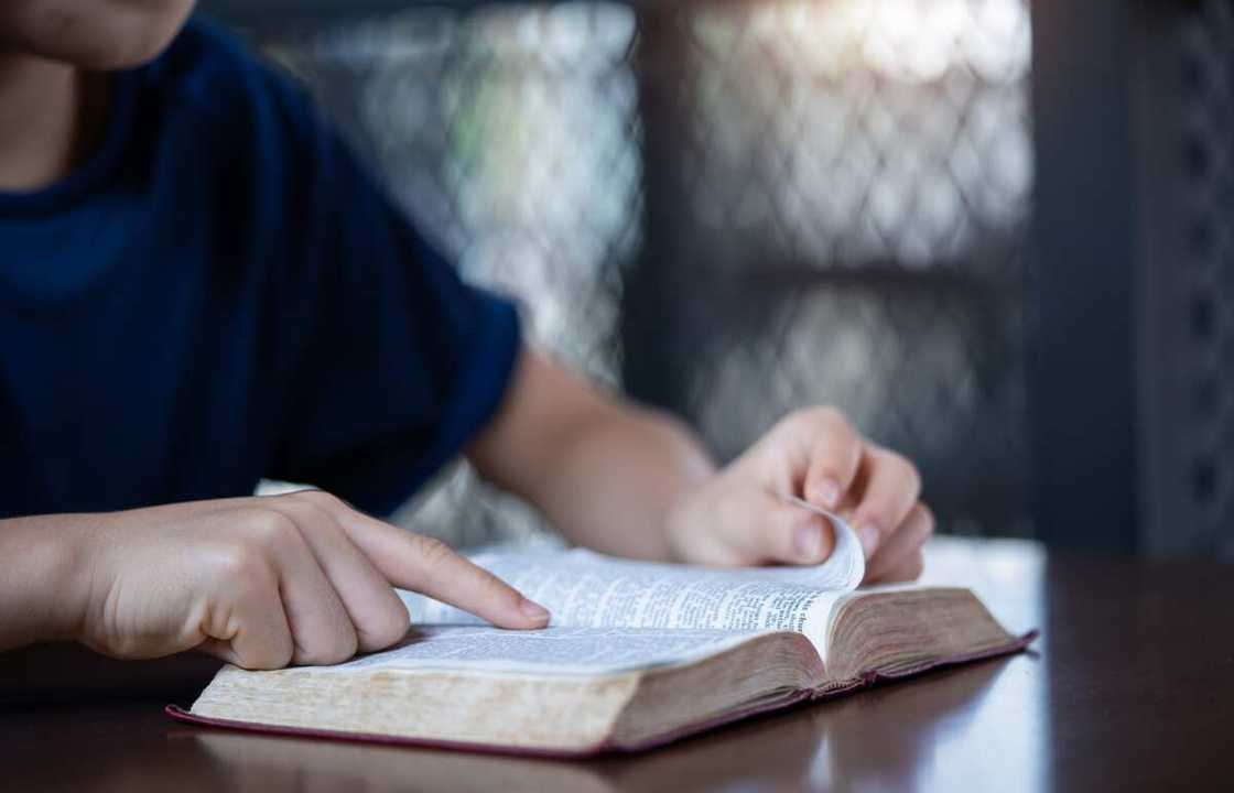 A person reading the Bible while pointing to the text with their finger A person reading the Bible while pointing to the text with their finger