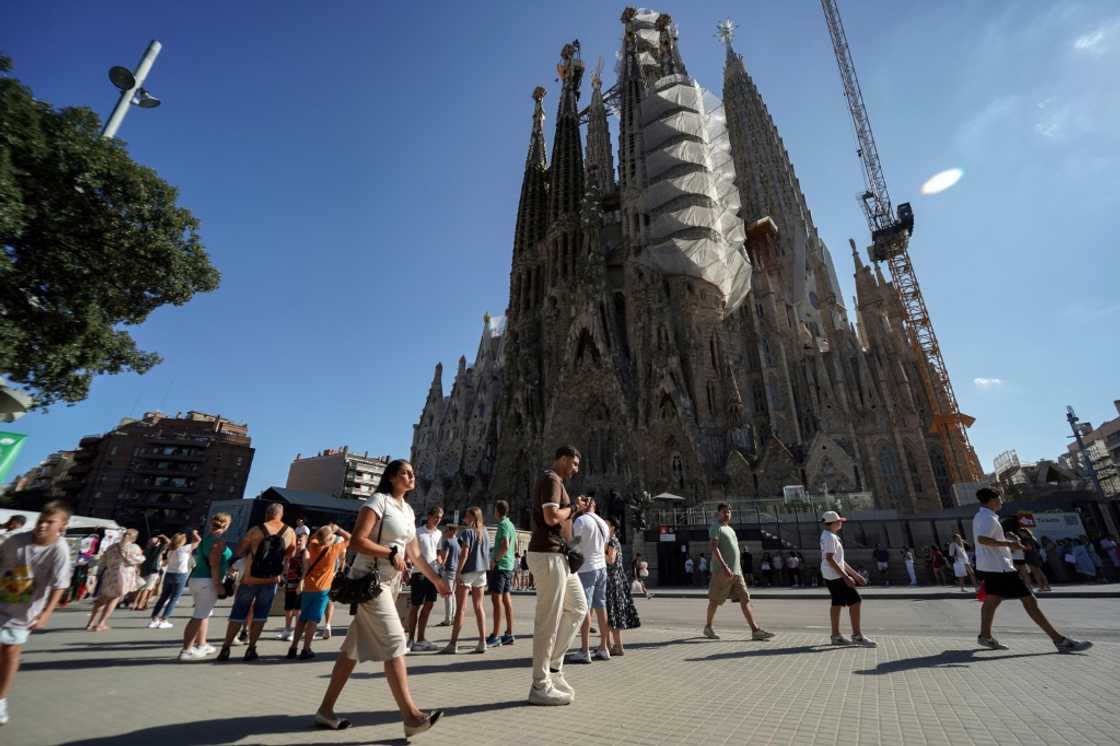 Tourists walk past the Sagrada Familia basilica in Barcelona on August 2, 2025 Tourists walk past the Sagrada Familia basilica in Barcelona on August 2, 2025
