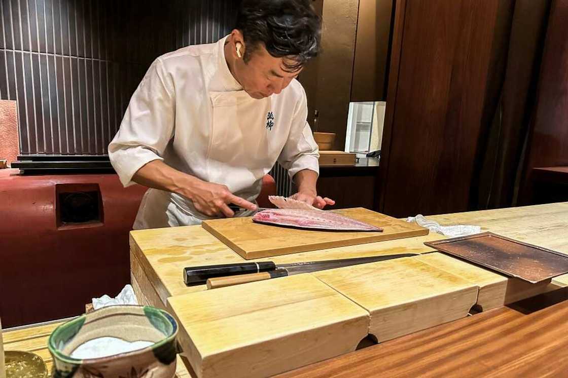 Chef Shintaro Matsuo expertly slices through a piece of yellowtail with a knife made in the nearby city of Sakai, at his restaurant in Osaka Chef Shintaro Matsuo expertly slices through a piece of yellowtail with a knife made in the nearby city of Sakai, at his restaurant in Osaka