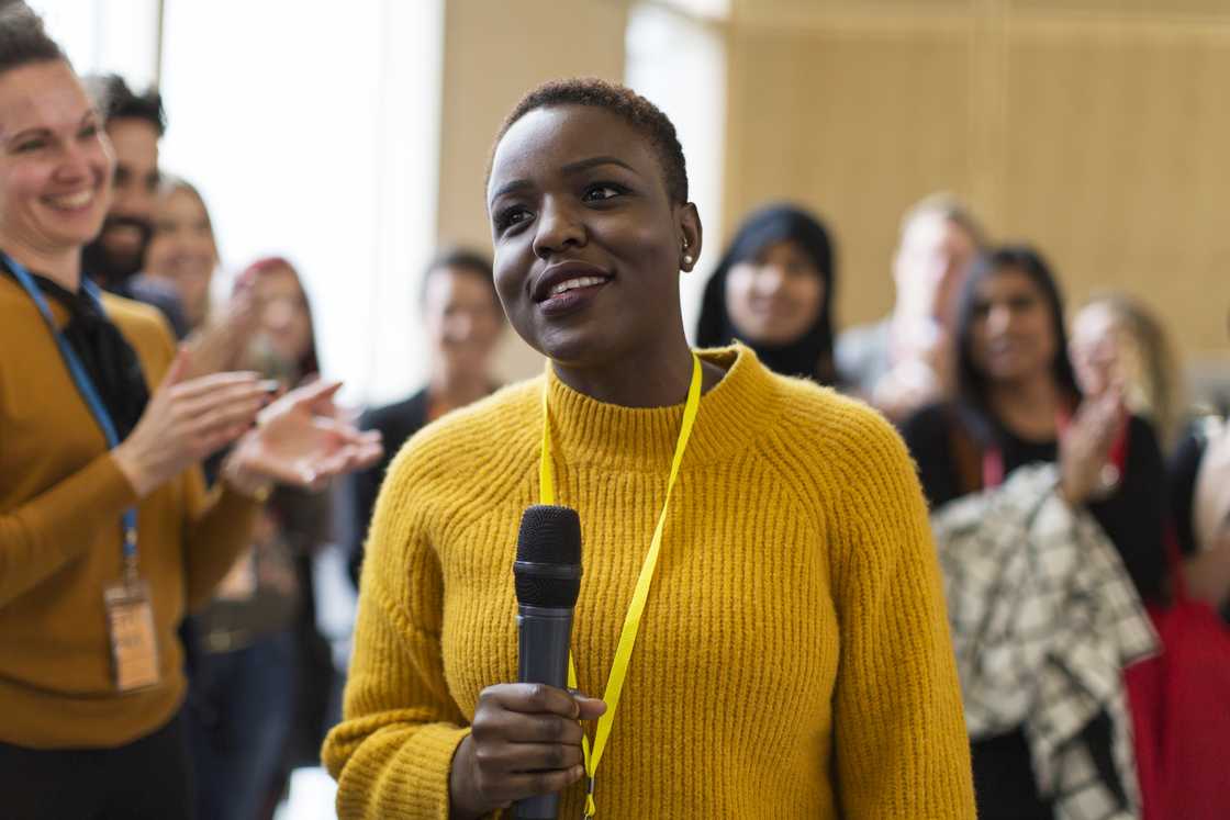 A woman addressing a small audience.