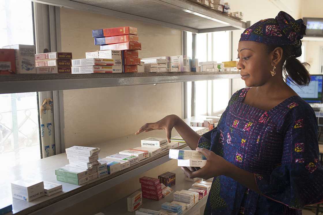 Pharmacist looking for medicine in a drug cabinet