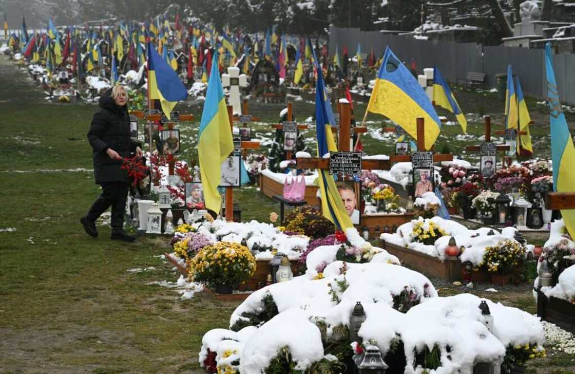 A local resident visits soldiers' graves on the Day of Dignity and Freedom at the Lychakiv Cemetery in Lviv, western Ukraine