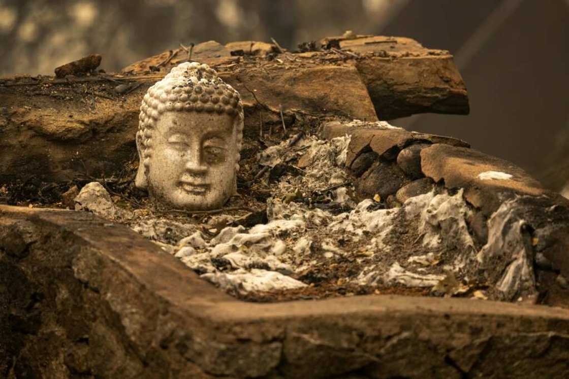 A burned statue lies in the ruins of a home in the community of Klamath River in northern California A burned statue lies in the ruins of a home in the community of Klamath River in northern California