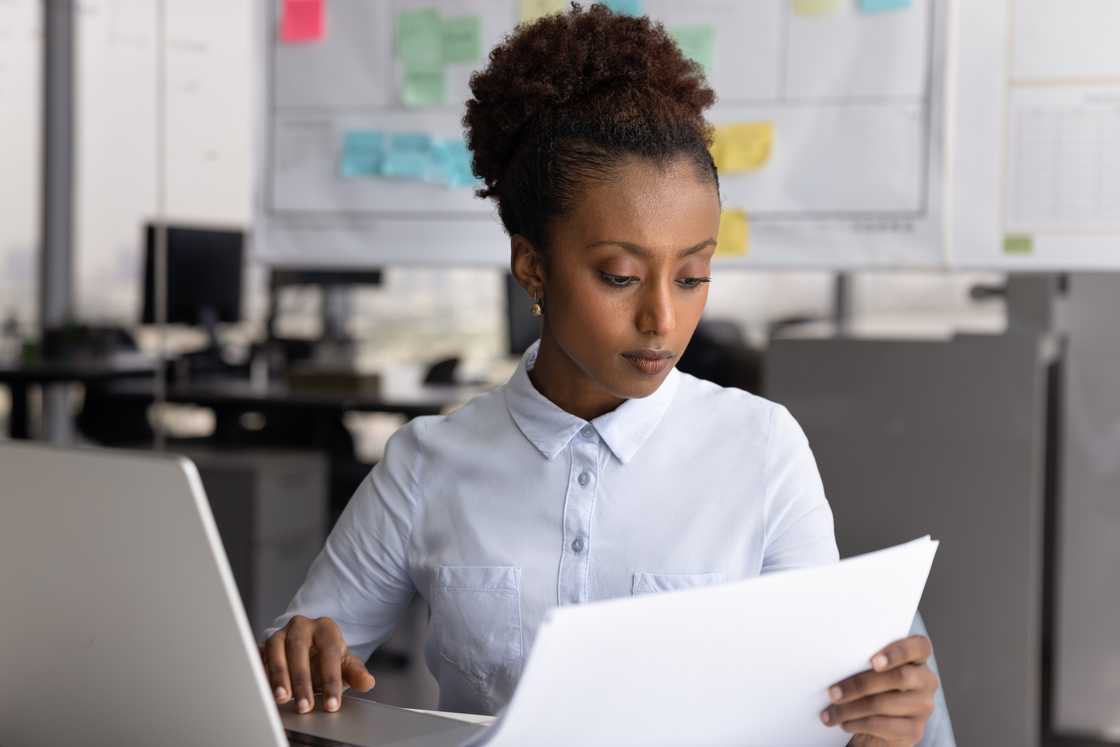 A lady in an office counterchecks the reports A lady in an office counterchecks the reports