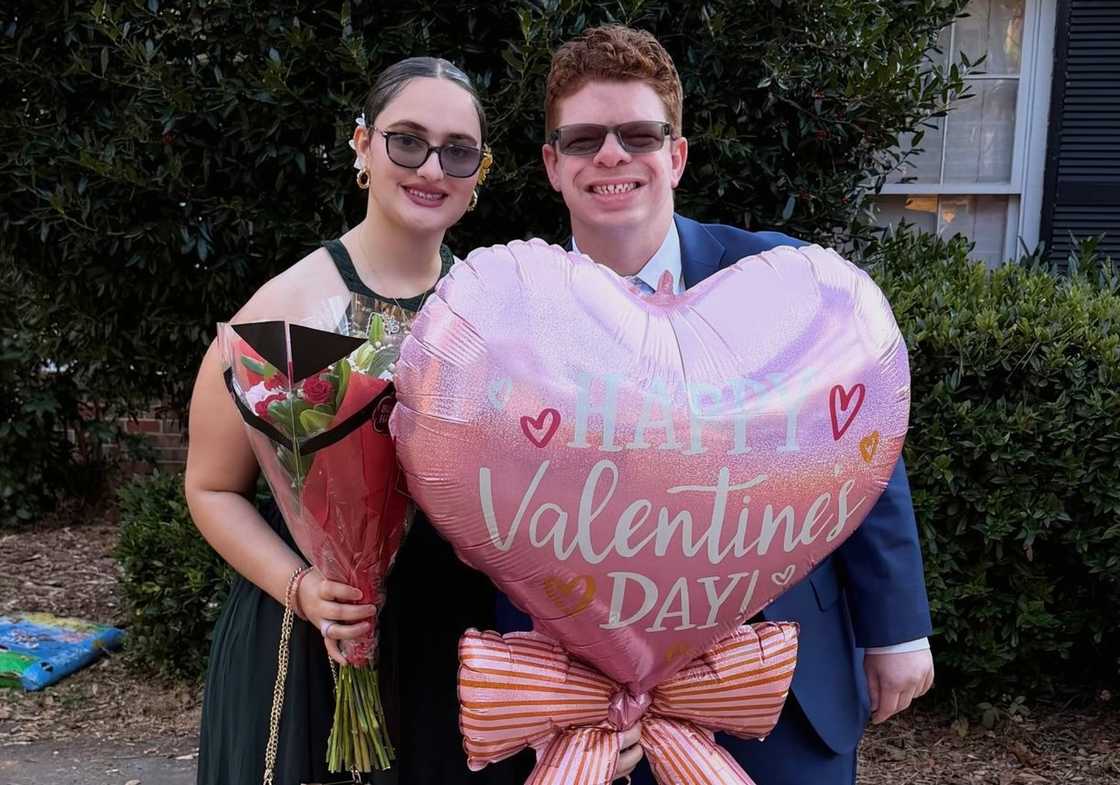 Georgie Harris and Luke Cardon pose with flowers and Valentine's Day balloon Georgie Harris and Luke Cardon pose with flowers and Valentine's Day balloon