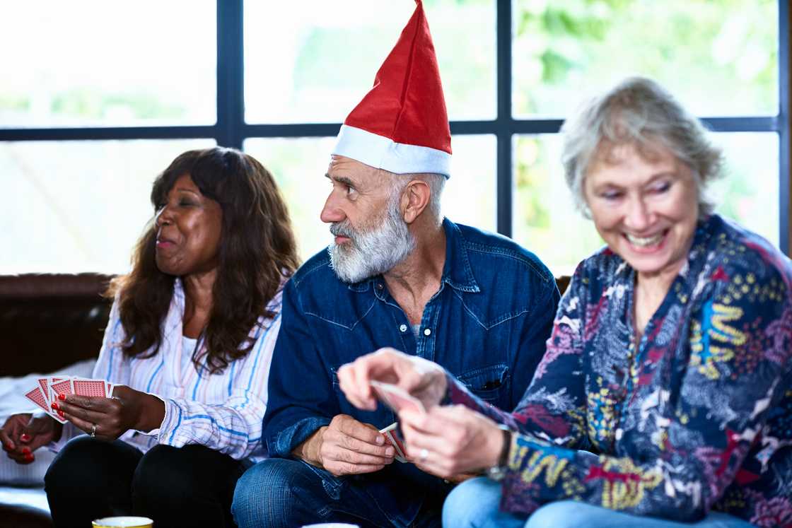 Three adults playing a card game