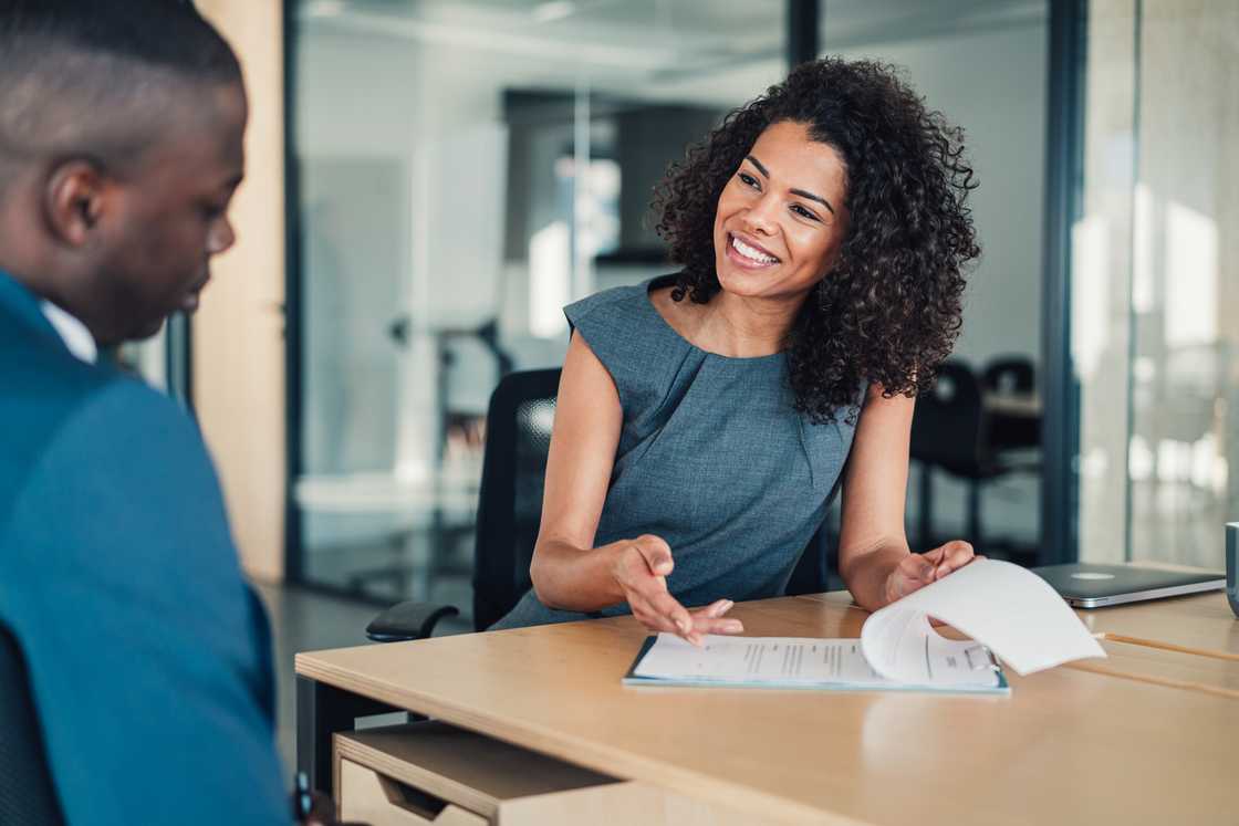 A man and woman filling in paperwork in the office. A man and woman filling in paperwork in the office.