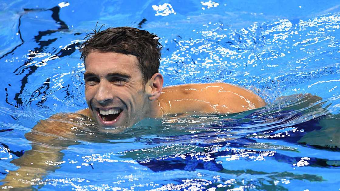 Swimmer Michael Phelps laughs in a pool