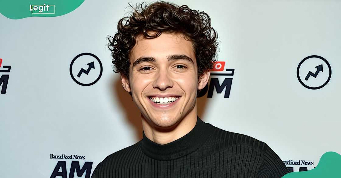 Joshua Bassett poses in front of a banner at the BuzzFeed's AM To DM studio