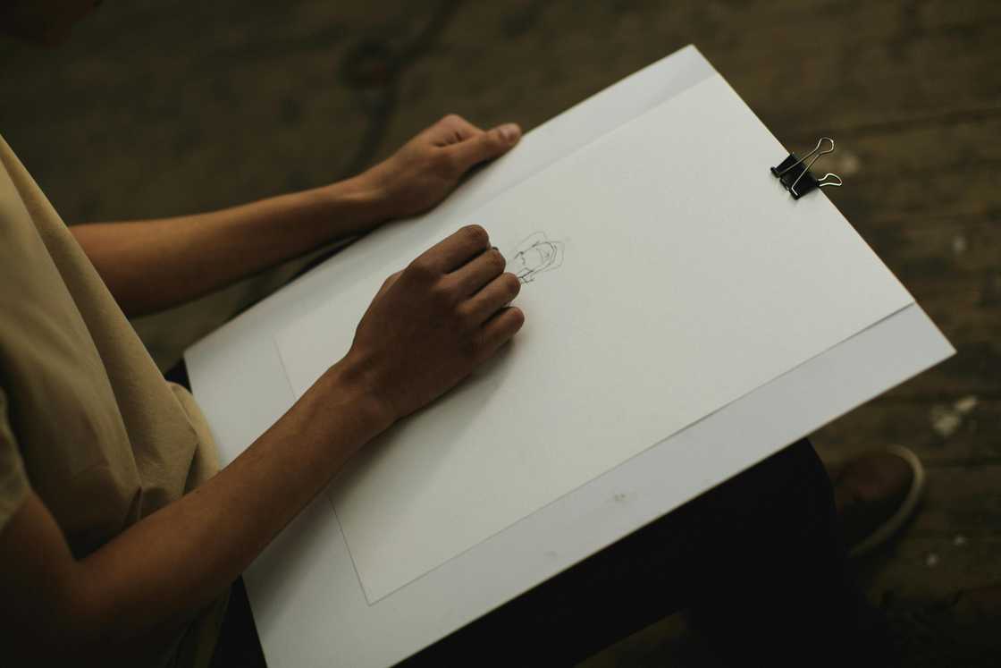 A person holding a white illustration board A person holding a white illustration board