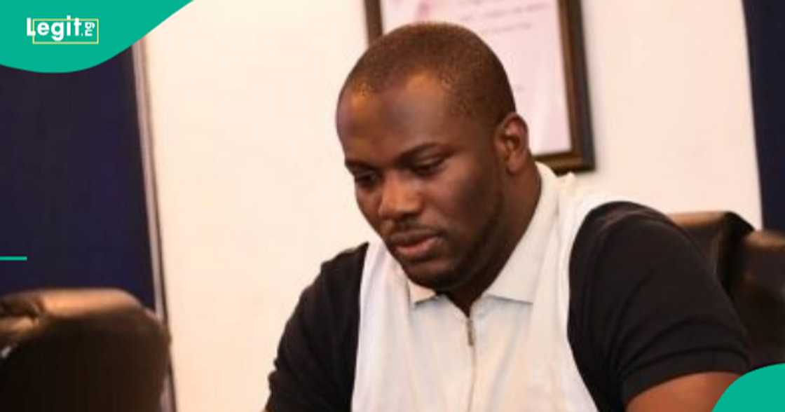 Man proudly shows off the examination result of an SS1 student who secured first position.