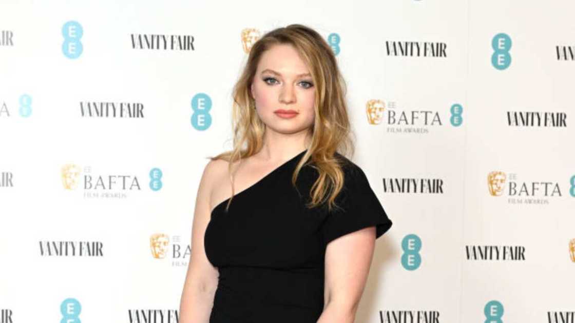 Mia Honey Threapleton posing for a picture in a black dress