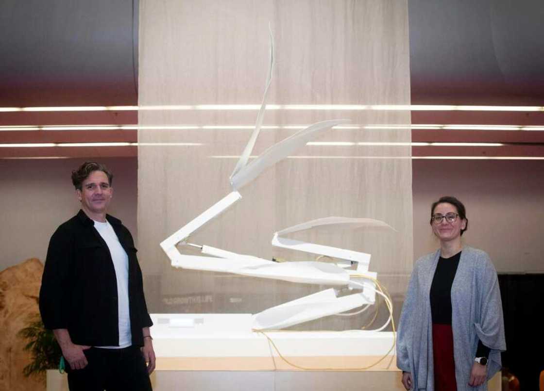 Dutch artist Thijs Biersteker (L) and scientist Adriana de Palma pose in front of "ECONARIO" an art installation by Biersteker, during the United the Nations Biodiversity Conference (COP15) in Montreal