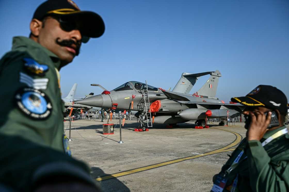 Indian Air Force (IAF) personnel stand in front of a Rafale fighter jet Indian Air Force (IAF) personnel stand in front of a Rafale fighter jet