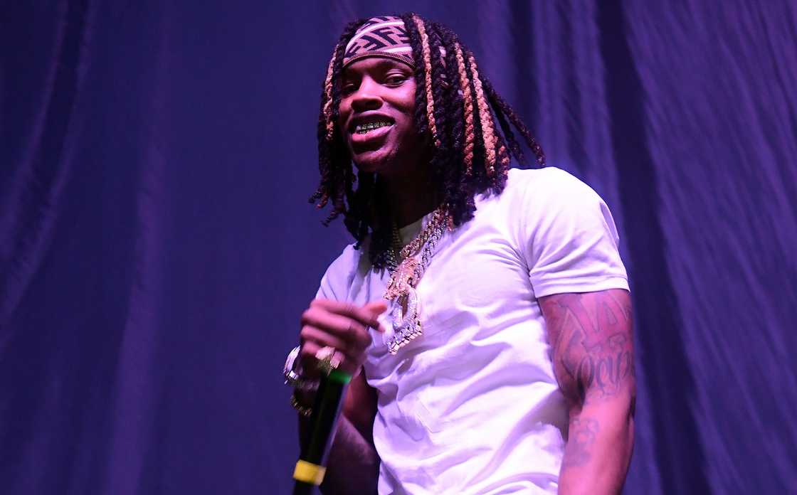 King Von holds a microphone while performing live.