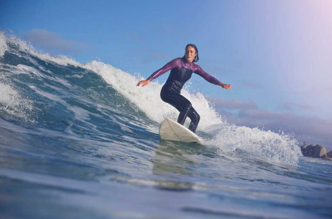 A person surfing at one one of Hawaiian beaches.