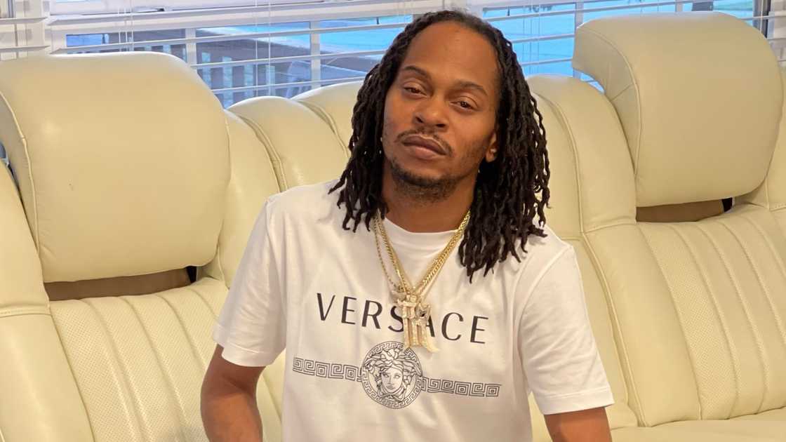 Playa Fly, sits on a cream couch.