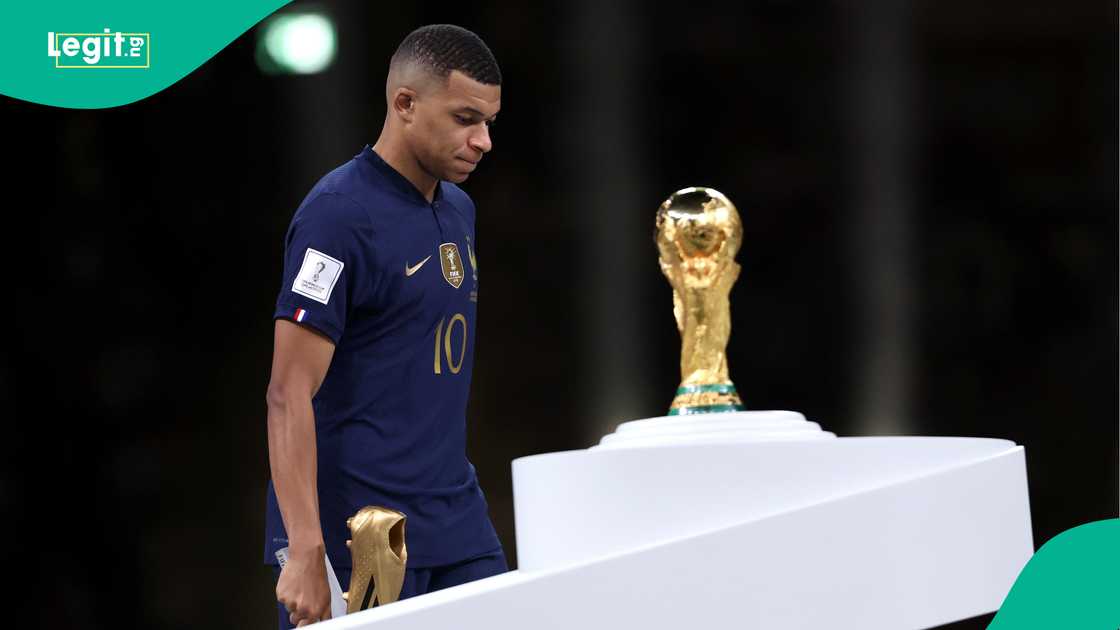 Kylian Mbappe walks past the World Cup trophy with his Golden Boot award in 2022. Photo by Clive Brunskill Kylian Mbappe walks past the World Cup trophy with his Golden Boot award in 2022. Photo by Clive Brunskill