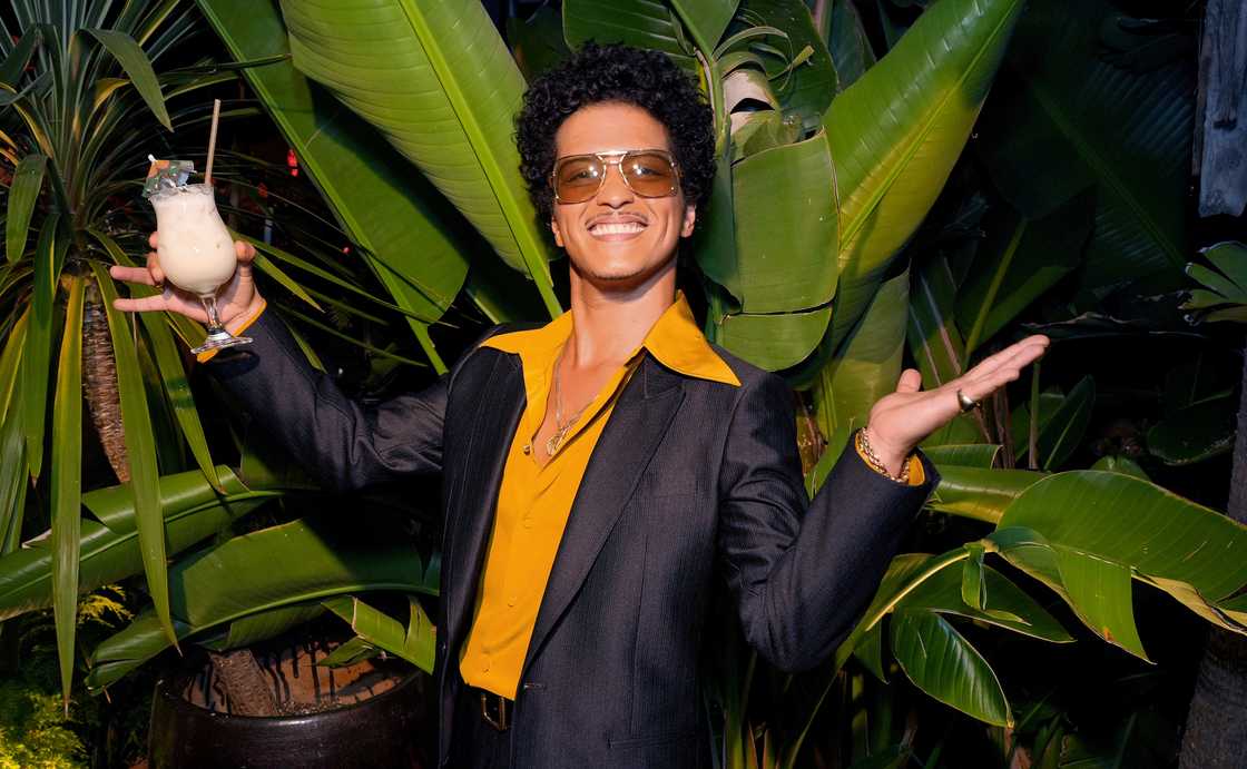 Bruno Mars poses with a drink at the SelvaRey Piña Colada party