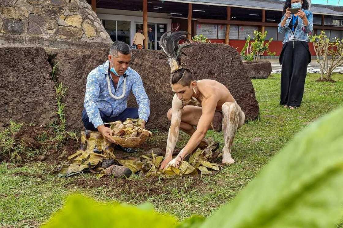 Easter Islanders pay their respects to the Mother Earth outside the island's airport ahead of the arrival of the first tourists in 28 months