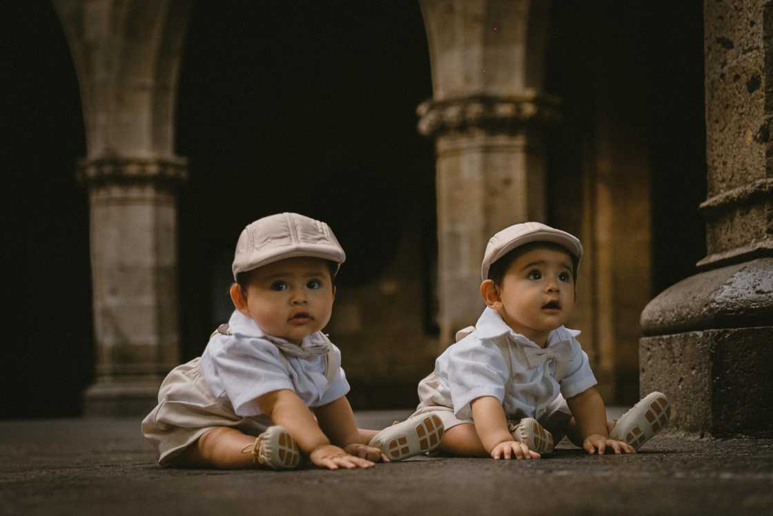 Twin Babies Sitting on Pavement