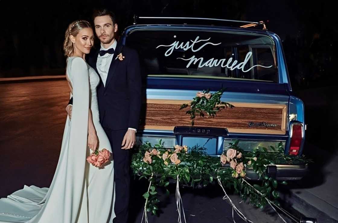 Hilary Duff and Matthew Koma pose beside a car Hilary Duff and Matthew Koma pose beside a car