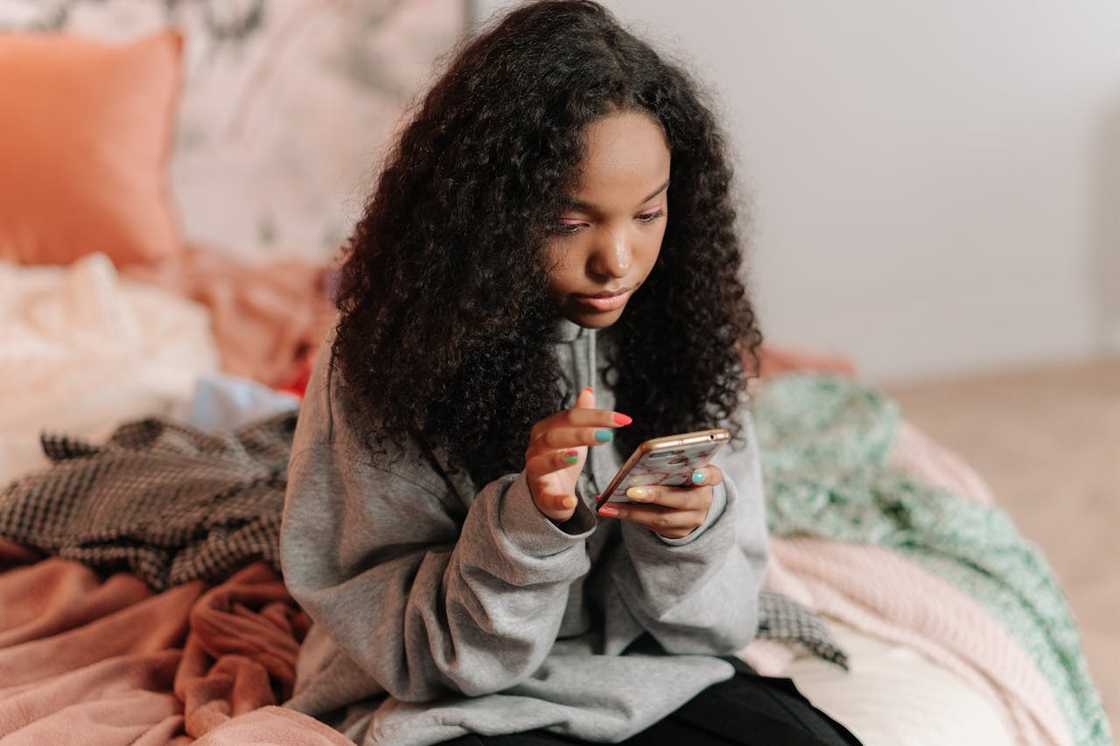 A teenage girl holding a phone.