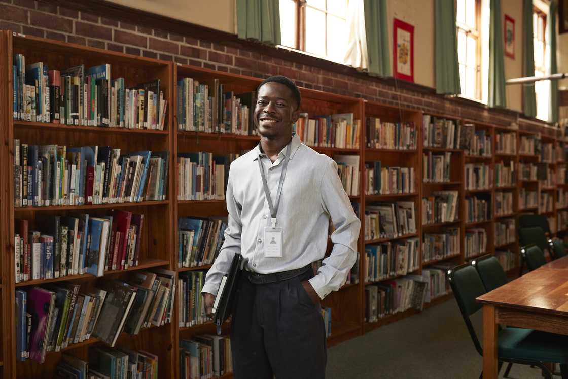 A librarian smiles as he looks on A librarian smiles as he looks on